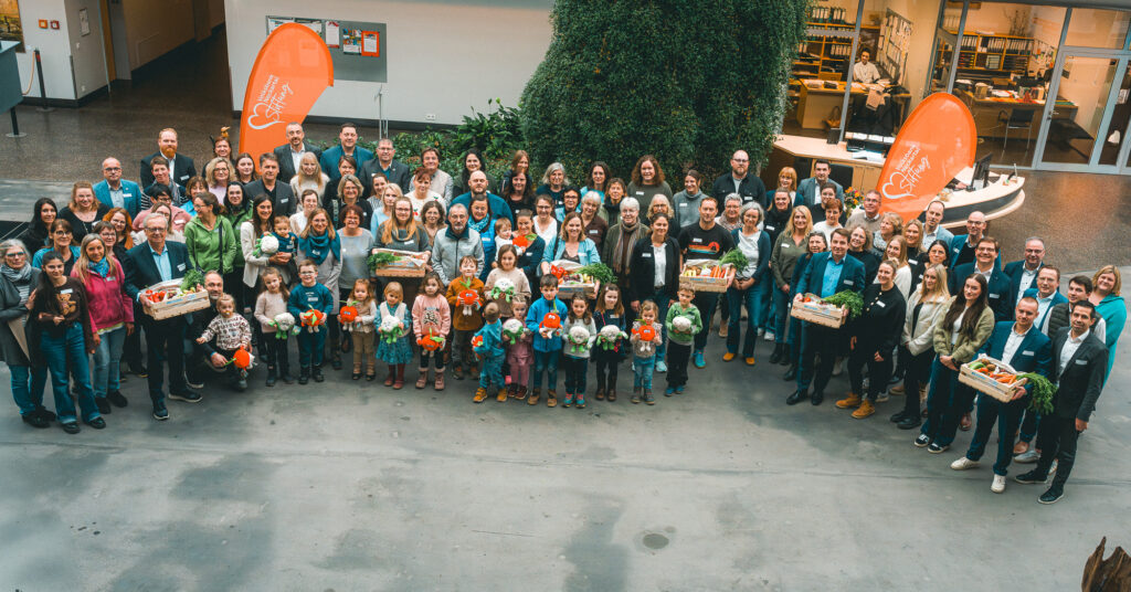 Eine große Gruppe von Menschen bei der Übergabe von Obst- und Gemüsekisten
